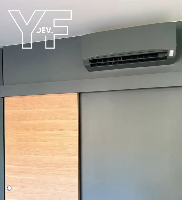 Climatisation anthracite intégrée au-dessus d'un placard bois, réalisation Y.F. DEV