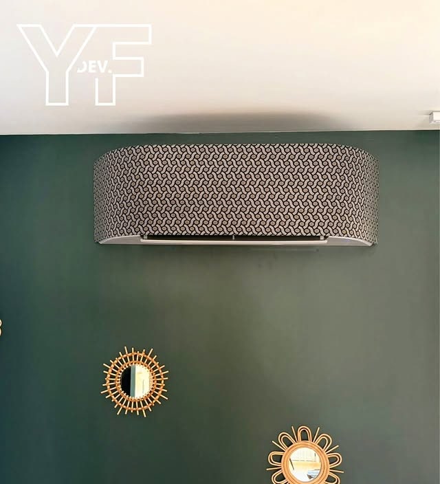 Climatisation habillée d'un cache décoratif sur un mur vert, réalisation Y.F. DEV